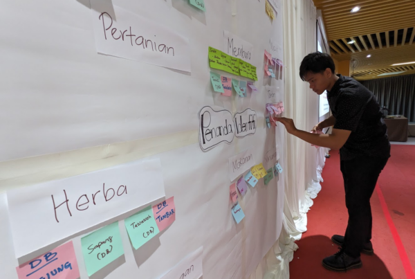 man putting post its on a wall as part of a workshop